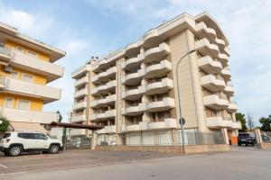 a large apartment building with a car parked in front at Casa di Franco in Alba Adriatica
