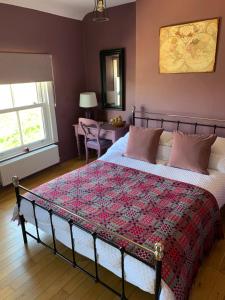 a bedroom with a bed with a quilt on it at Efail Y Garn in Swansea