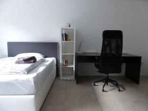 バート・ノイシュタット・アン・デア・ザーレにあるApartment Sonnenscheinのベッドルーム1室(ベッド1台、デスク、椅子付)