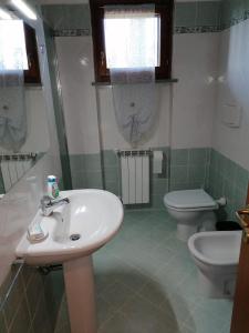 y baño con lavabo y aseo. en Casa nel Borgo, en Montemerano