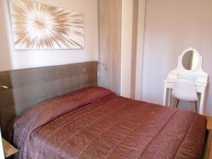 1 dormitorio con 1 cama con colcha roja en Casa nel Borgo, en Montemerano