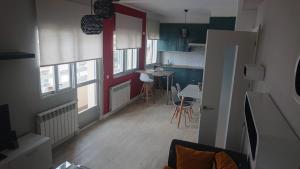 a living room with a red door and a kitchen at Foz Playas in Foz