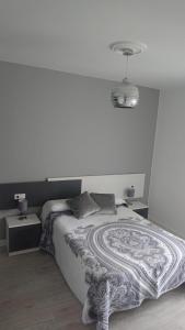 a bedroom with a bed with a white wall at Foz Playas in Foz