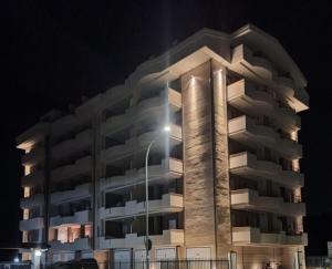 a tall apartment building at night with a street light at Casa di Franco in Alba Adriatica +2 photos