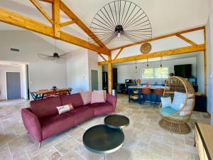 a living room with a couch and a table at Magnifique villa avec piscine in Escource