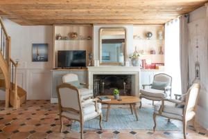 a living room with a fireplace and a table and chairs at La Martinoise Patio in Saint-Martin-de-Ré