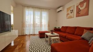 a living room with a red couch and a television at Memories apartment in Mostar