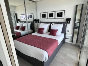a bedroom with two beds with red and white pillows at MyBlueVista LUXURY PANORAMIC SEA VIEW APARTMENTS CAP D AIL NEAR MONACO in Cap d'Ail