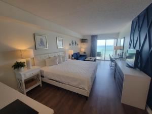 een slaapkamer met een bed en een televisie in een kamer bij Beautifully Updated Ocean Front King Suite! Sea Mist Resort 20806 - Perfect for 2-4 guests! in Myrtle Beach