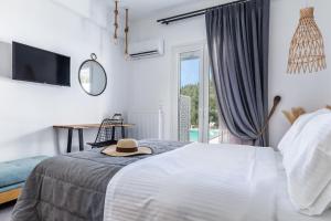a bedroom with a bed with a hat on it at Ninemia Villa in Skopelos in Skopelos Town +11 photos