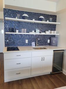een keuken met witte kasten en een blauwe tegelmuur bij Beautifully Updated Ocean Front King Suite! Sea Mist Resort 20806 - Perfect for 2-4 guests! in Myrtle Beach