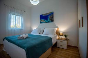 a bedroom with a large bed with a blue blanket at My Adriatic Place with private garden in Šibenik