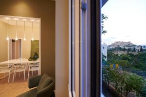 a dining room with a table and a view from a window at Ma Maison Acropolis Mansion, Suite No6, Ultra High Speed Internet 500 Mbps, 500 meters from Acropolis in Athens