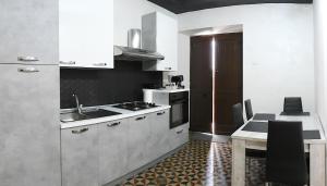 a kitchen with white cabinets and a table with a sink at BlueSky in Mascali
