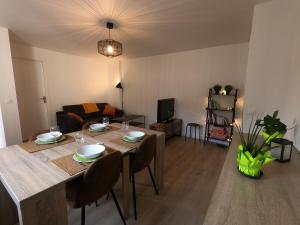 een eetkamer en een woonkamer met een tafel en stoelen bij Besançon appartement T2 sur cour intérieure proximité gare in Besançon