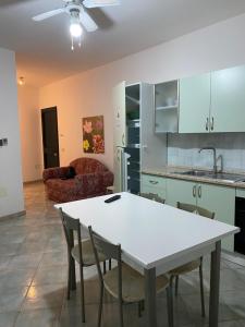 uma cozinha e sala de estar com uma mesa branca e cadeiras em Appartamenti Saverio em Posada