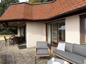 a patio with a couch and chairs and a table at Ferienwohnung Bodenseeblick in Meersburg