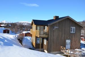 ein Haus mit einer Terrasse im Schnee in der Unterkunft Ramundberget Skarsgården in Bruksvallarna