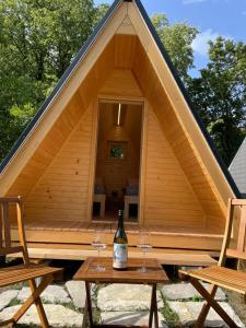 - une bouteille de vin assise sur deux tables devant une tente dans l'établissement Vila Noblesa, à Most na Soči