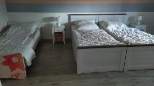 1 Schlafzimmer mit 2 Betten und 2 Nachttischen in der Unterkunft FeWo unter den Eichen in Wienrode