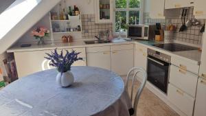 a kitchen with a table with a vase of flowers on it at Ferienwohnung in Bad Wilhelmshöhe Weltkulturerbe in Kassel