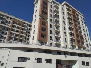 a tall white building with balconies on top of it at Green Residence in Palilula