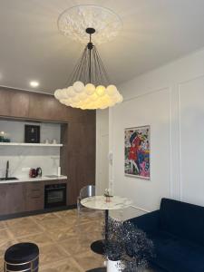 ein Wohnzimmer mit einem Tisch und einem Kronleuchter in der Unterkunft Studio Fleuri in Cannes