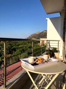 una mesa con una bandeja de comida en el balcón en Oikia Stone House in seaside Kalo Chorio, en Agios Nikolaos