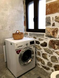 阿基歐斯尼古拉斯的住宿－Oikia Stone House in seaside Kalo Chorio，洗衣机上方有一个篮子