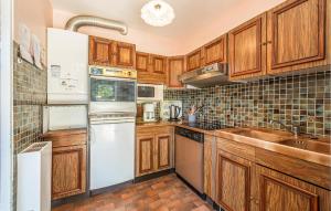 eine Küche mit Holzschränken und weißen Geräten in der Unterkunft Holiday Home Les Moutiers En Retz Rue De Bois Millet in Les Moutiers + 6 Fotos