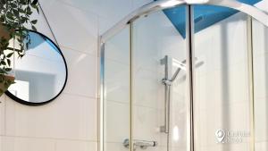 een douche met een glazen deur en een spiegel bij Smallest House in Chester - Cosy 1 Bedroom Home in Chester