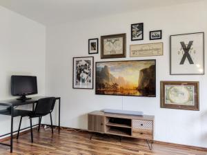 een kamer met een tv en een bureau en foto's aan de muur bij INIKAMA: Designer Apartment im Grünen – Netflix in Rosengarten