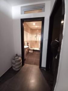 - un couloir avec une salle de bains pourvue d'une baignoire et d'un lavabo dans l'établissement A & A TERANGA, à La Somone