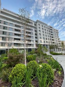 an apartment building with a garden in front of it at Apartament Nadmorski - Plac Unii - Parking in Gdynia