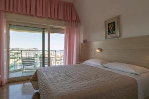 a bedroom with a large bed and a balcony at Hotel Silver in Milano Marittima