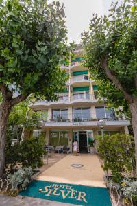 a woman standing in front of a building at Hotel Silver in Milano Marittima