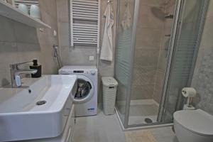 a bathroom with a sink and a washing machine at Bonaca in Senj +34 photos