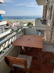 balcone con tavolo in legno e vista sull'oceano di Casa vacanze Mare Blu a Bellaria-Igea Marina