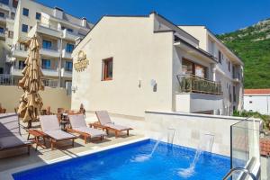 a villa with a swimming pool and a building at Vistamar Hotel & Apartments in Budva