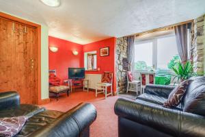 a living room with a couch and a television at Knott View in Milnthorpe