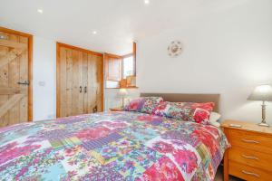 a bedroom with a bed with a colorful comforter at Knott View in Milnthorpe