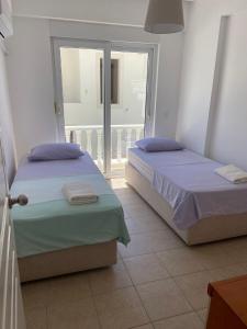two beds sitting in a room with a balcony at Fantastic Apt-2 min walk from Belek Cent’r Antalya region, great for golf lovers in Belek +45 photos