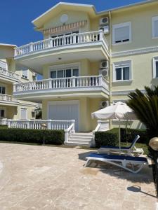 a large house with a patio and an umbrella at Fantastic Apt-2 min walk from Belek Cent’r Antalya region, great for golf lovers in Belek