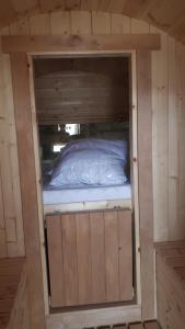 Cette petite chambre comprend un lit dans une maison en bois. dans l'établissement Un tonneau à la belle étoile, à Irancy