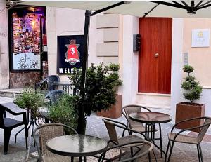 ポテンツァにあるLa Piazzetta Suiteの赤いドア、テーブルと椅子付きのパティオ