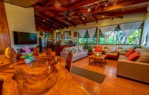 sala de estar amplia con mesa de madera y sofá en Villas Oasis, en Manuel Antonio