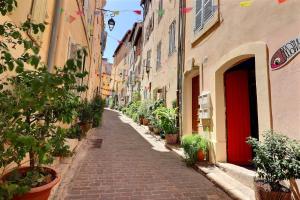 una calle estrecha con plantas a los lados de los edificios en La Sardine du Panier® en Marsella