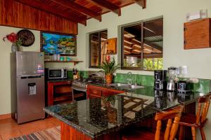 a kitchen with a granite counter top and stainless steel appliances at Villas Oasis in Manuel Antonio