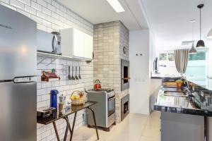 cocina con paredes blancas y electrodomésticos blancos en Sinta-se em casa a 500m do MAR na Praia Brava, en Balneário Camboriú