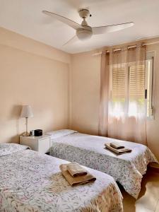 a bedroom with two beds and a ceiling fan at APARTAMENTO DIEGO EN SANTA CRUZ CON PARKING PRIVADO GRATIS in Santa Cruz de Tenerife